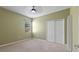 This bedroom is carpeted, has a ceiling fan, closet, and a large window at 555 Presido Park Pl, Kissimmee, FL 34759