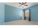 This is a carpeted bedroom with a ceiling fan and natural light from the window at 555 Presido Park Pl, Kissimmee, FL 34759