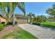 Two car garage view showing lush landscaping, a paver driveway and tropical plants at 555 Presido Park Pl, Kissimmee, FL 34759