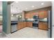 Modern kitchen featuring stainless steel appliances, a large window, wood cabinets and tile flooring at 555 Presido Park Pl, Kissimmee, FL 34759