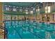 Indoor swimming pool featuring clear water, abundant natural light, and blue lane markers at 555 Presido Park Pl, Kissimmee, FL 34759