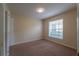 Cozy bedroom featuring neutral carpet, light walls, and a bright window overlooking the front yard at 635 Lake Marion Golf Resort, Kissimmee, FL 34759