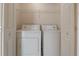 Bright laundry room featuring a white washer and dryer, wire shelving, and neutral walls at 635 Lake Marion Golf Resort, Kissimmee, FL 34759