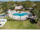 Aerial view of a community pool area, including a pool, spa, lounge chairs, and tropical landscaping at 635 Lake Marion Golf Resort, Kissimmee, FL 34759