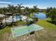 Aerial view of a community shuffleboard court, pool, and spa, situated near a serene lake at 635 Lake Marion Golf Resort, Kissimmee, FL 34759