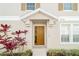 Inviting front entrance featuring a stylish door with sidelight, enhanced by colorful plants and modern house numbers at 7128 Red Lantern Dr # 0, Harmony, FL 34773