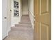 Carpeted staircase illuminated by natural light, complemented by modern artwork and a freshly painted wall at 7128 Red Lantern Dr # 0, Harmony, FL 34773