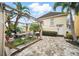 Charming backyard patio featuring a pergola, lush landscaping, and stone pavers perfect for outdoor relaxation and entertaining at 7623 Excitement Dr, Reunion, FL 34747