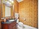 Half bathroom with decorative wallpaper, carved vanity, and ornate mirror at 7623 Excitement Dr, Reunion, FL 34747