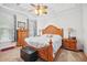 Spacious bedroom with a ceiling fan, a large carved wood bed, a dresser, and carpet at 7623 Excitement Dr, Reunion, FL 34747