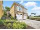 Beautiful exterior view of a two-story home with a brick driveway and lush landscaping at 7623 Excitement Dr, Reunion, FL 34747