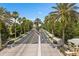 Well maintained community entrance drive surrounded by palm trees and lush landscaping on a sunny day at 7660 Otterspool St, Kissimmee, FL 34747