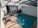 Inviting screened-in pool featuring a tanning deck, step entry, and outdoor furniture at 7660 Otterspool St, Kissimmee, FL 34747