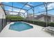 The backyard features an in-ground swimming pool enclosed by a screen and lined with manicured hedges at 8122 Yellow Crane Dr, Kissimmee, FL 34747