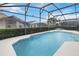 Picture of an in-ground swimming pool with a screened enclosure and manicured hedges at 8122 Yellow Crane Dr, Kissimmee, FL 34747