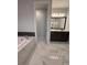 Bathroom featuring an open doorway, dual sink vanity, soaking tub, and elegant marble tile flooring at 8289 Topsail Pl, Winter Garden, FL 34787