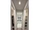 Hallway leading to modern bathroom with tub and dual closets for storage at 8289 Topsail Pl, Winter Garden, FL 34787