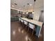 Modern kitchen boasts an expansive island with seating, gray cabinets, and stainless steel appliances at 8289 Topsail Pl, Winter Garden, FL 34787