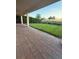 Spacious brick patio overlooking a manicured lawn and tropical landscaping, perfect for outdoor entertaining at 8289 Topsail Pl, Winter Garden, FL 34787