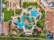 Stunning aerial view showcasing pools, lush landscaping, sun loungers, water slides, and a colorful splash zone at 841 Retreat Blvd # 101, Davenport, FL 33897