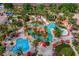 Aerial view of a resort pool with a lazy river, splash pad, and lush landscaping, perfect for vacation fun at 841 Retreat Blvd # 101, Davenport, FL 33897