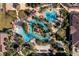 A scenic aerial view of community pools, lush landscaping, sun loungers, bridges, and serene water features at 841 Retreat Blvd # 101, Davenport, FL 33897