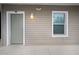 Apartment entrance featuring a well-lit doorway, a unit number, and a window with privacy blinds at 841 Retreat Blvd # 101, Davenport, FL 33897