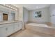 Bathroom with tile flooring, granite double vanity, and large tub at 943 Van Loon Ct, Kissimmee, FL 34758
