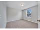 A well-lit bedroom offers neutral walls, carpet flooring, and a window view at 943 Van Loon Ct, Kissimmee, FL 34758