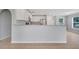 Open kitchen with white cabinetry, granite counters, and bar top area for seating at 943 Van Loon Ct, Kissimmee, FL 34758
