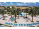 Aerial view of community pool area with waterslide, seating, and lush landscaping at 1048 Leader St, Davenport, FL 33896