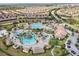 Aerial view of a community pool, playground, clubhouse, parking, and lush landscaping at 1048 Leader St, Davenport, FL 33896