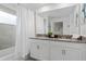 Well-lit bathroom with dual sinks, a large mirror, and modern fixtures at 1048 Leader St, Davenport, FL 33896