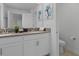 Modern bathroom featuring double vanity with stone countertop, decorative art, and a toilet at 1048 Leader St, Davenport, FL 33896
