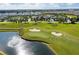 An aerial view of a lush golf course with a scenic pond and fountain in a residential community at 1048 Leader St, Davenport, FL 33896