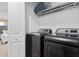 Convenient laundry room with modern washer and dryer and shelving for storage at 1048 Leader St, Davenport, FL 33896