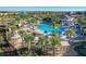 Resort-style pool area with tropical landscaping, cabanas, lounge chairs, and a building with a dark roof at 1048 Leader St, Davenport, FL 33896