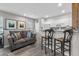 Inviting living space with a gray sofa, bar seating, and a kitchenette with white cabinets at 1154 Celebration Ave, Celebration, FL 34747