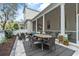 A covered patio features an outdoor dining set and a cozy seating area with a fireplace and lush greenery at 1154 Celebration Ave, Celebration, FL 34747
