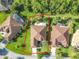 An aerial view shows the home's lot and proximity to lush landscaping, mature trees, and neighboring properties at 133 Indian Wells Ave, Kissimmee, FL 34759