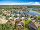 Aerial view of home near a lake with lush greenery, in a peaceful residential neighborhood with beautiful landscaping at 133 Indian Wells Ave, Kissimmee, FL 34759