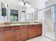 Bright bathroom features double vanity with granite countertop, tile floors, and glass-enclosed shower at 133 Indian Wells Ave, Kissimmee, FL 34759