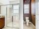 Bright bathroom features glass-enclosed shower with bench and separate toilet room with chandelier at 133 Indian Wells Ave, Kissimmee, FL 34759