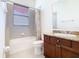 Bright bathroom with a shower-tub combination, single sink vanity, and tiled floor at 133 Indian Wells Ave, Kissimmee, FL 34759