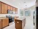 Modern kitchen with stainless appliances, an island with granite countertops, and ample cabinet space at 133 Indian Wells Ave, Kissimmee, FL 34759
