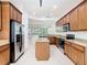 Open-concept kitchen features stainless steel appliances, a kitchen island and tiled floor at 133 Indian Wells Ave, Kissimmee, FL 34759