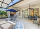 Screened patio featuring ceiling fans, seating, a table with an umbrella, and a view of the backyard at 133 Indian Wells Ave, Kissimmee, FL 34759