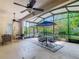 Screened patio featuring ceiling fans, seating, a table with an umbrella, and a view of the backyard at 133 Indian Wells Ave, Kissimmee, FL 34759