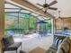 Screened patio featuring ceiling fans, seating, a table with an umbrella, and a view of the backyard at 133 Indian Wells Ave, Kissimmee, FL 34759