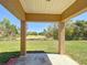 View of a covered back porch overlooking a spacious backyard with trees beyond the fence line at 15069 Sw 29Th Avenue Rd, Ocala, FL 34473